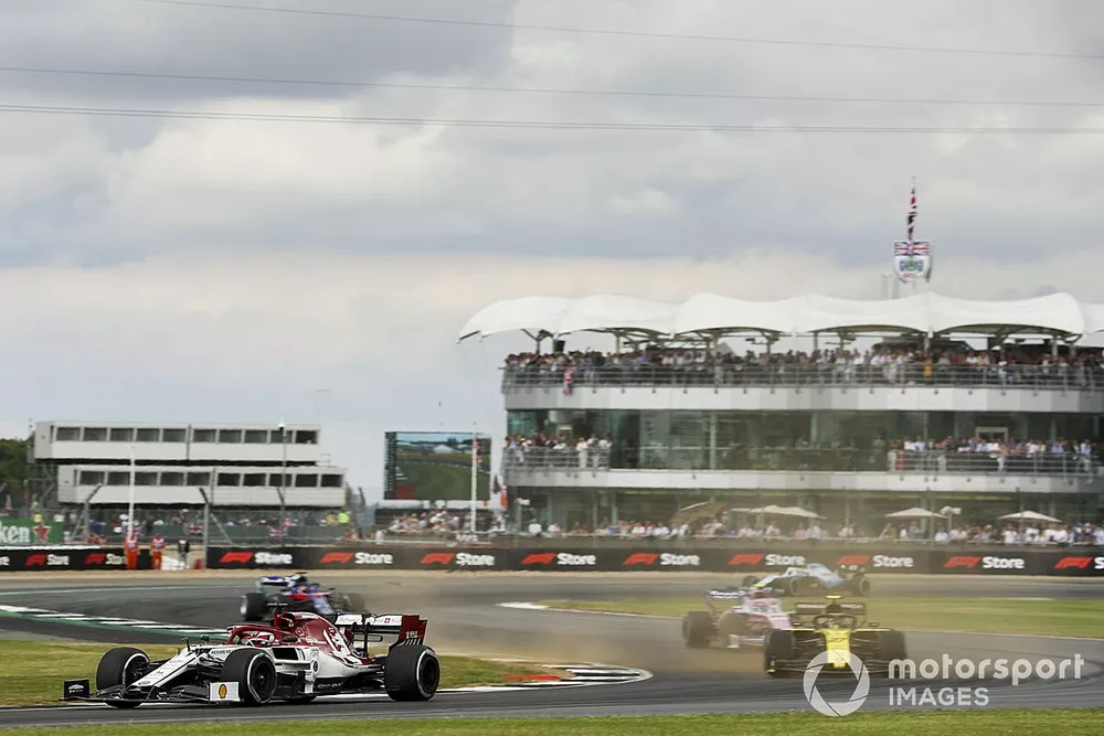 Kimi Raikkonen, Alfa Romeo Racing C38, voor Nico Hulkenberg, Renault F1 Team R.S. 19, Lance Stroll, Racing Point RP19, en de rest van het veld bij de start