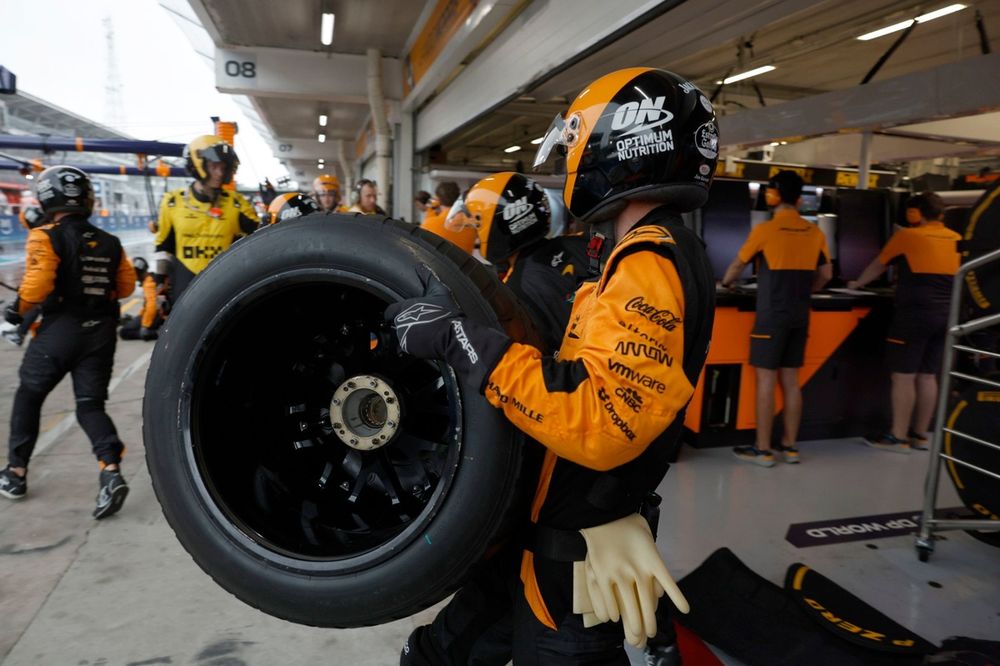 A equipe de box da McLaren sai da garagem para um pit stop