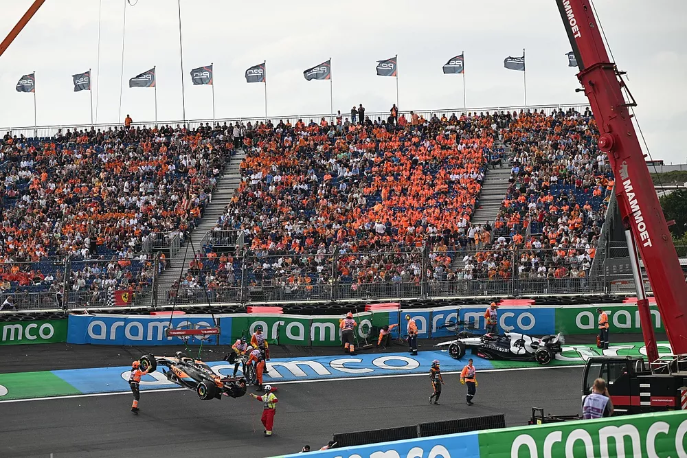 Los oficiales de pista retiran los coches da&ntilde;ados de Oscar Piastri, McLaren MCL60, y Daniel Ricciardo, AlphaTauri AT04.