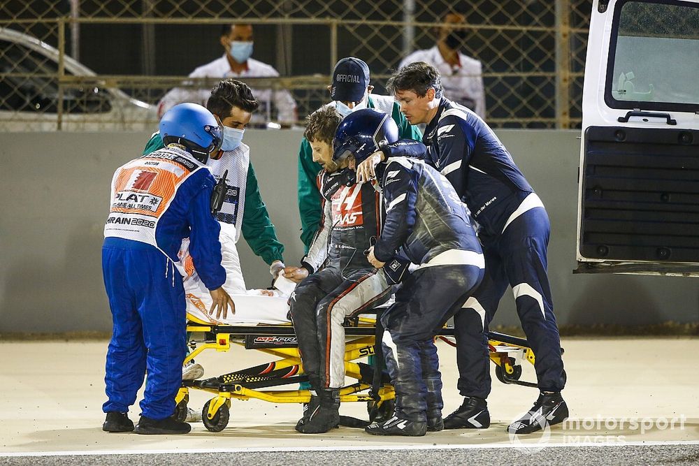Medical delegates assist Romain Grosjean, Haas F1, after a huge crash on the opening lap