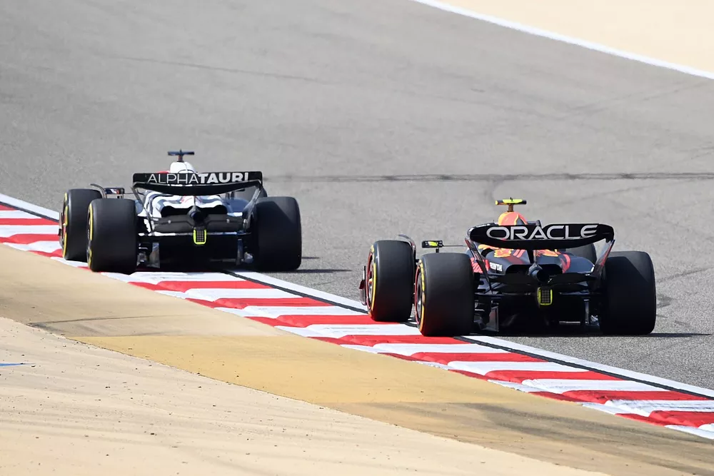 Nyck de Vries, AlphaTauri AT04, leads Sergio Perez, Red Bull Racing RB19