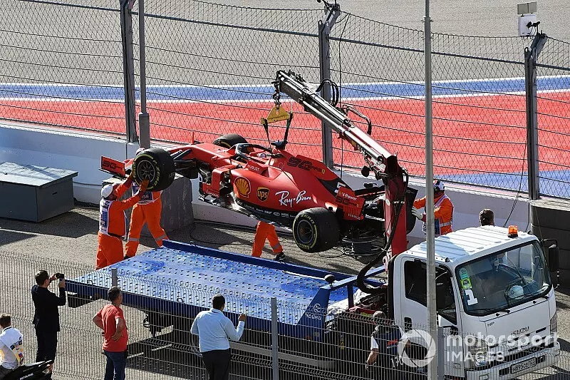 Marshals load the car of Sebastian Vettel, Ferrari SF90, onto a truck