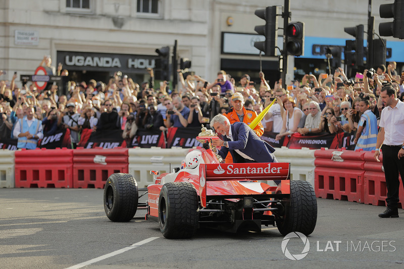 Jenson Button, McLaren, da un paseo de pasajero a Naomi Campbell en 2 plazas y Damon Hill ofrece el trofeo British Grand Prix como una broma