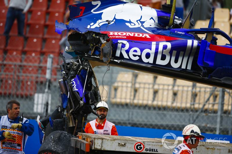 Marshals remove the damaged car of Brendon Hartley, Toro Rosso STR13, from the circuit as the gearbox hangs off the back