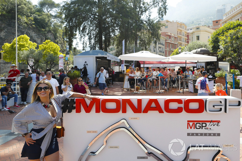 A lady poses next to a Monaco Grand Prix sign