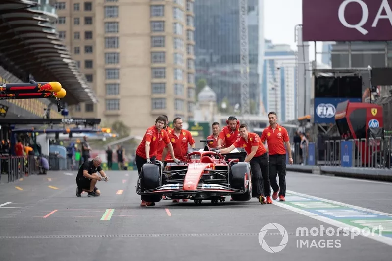 The car of Charles Leclerc, Ferrari SF-24 is wheeled down the pit lane by team members