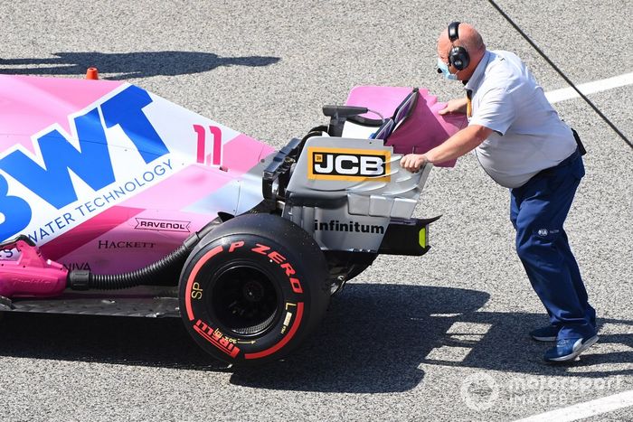 Un inspector de la FIA empuja el monoplaza de Sergio Pérez, Racing Point RP20 en Parc Ferme