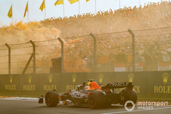 Max Verstappen, Red Bull Racing RB18, 1ª posición, saluda desde su cabina mientras los aficionados tiñen el aire de naranja en señal de celebración