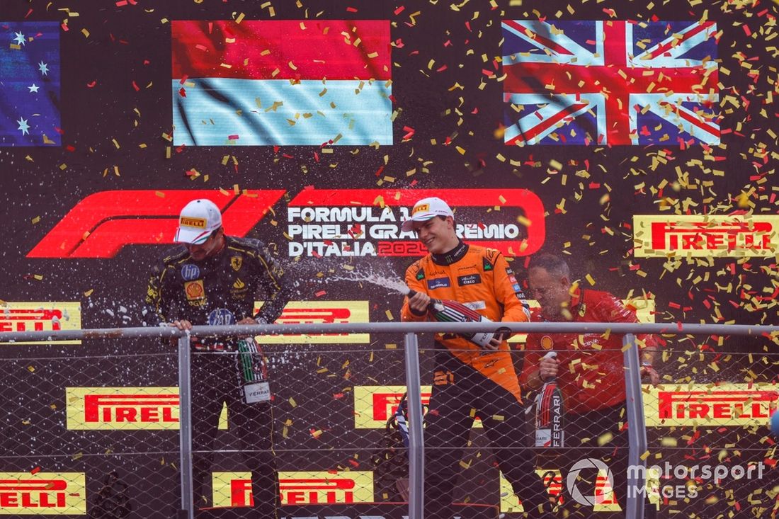 Charles Leclerc, Scuderia Ferrari, 1ª posición, Oscar Piastri, McLaren F1 Team, 2ª posición, rocío de champán en el podio.