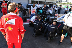 Ingeniero de Ferrari observa el coche de Lewis Hamilton, Mercedes AMG F1 W08