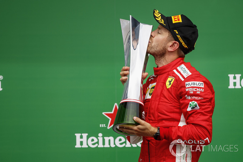 Sebastian Vettel, Ferrari, 1st position, celebrates by kissing his trophy on the podium