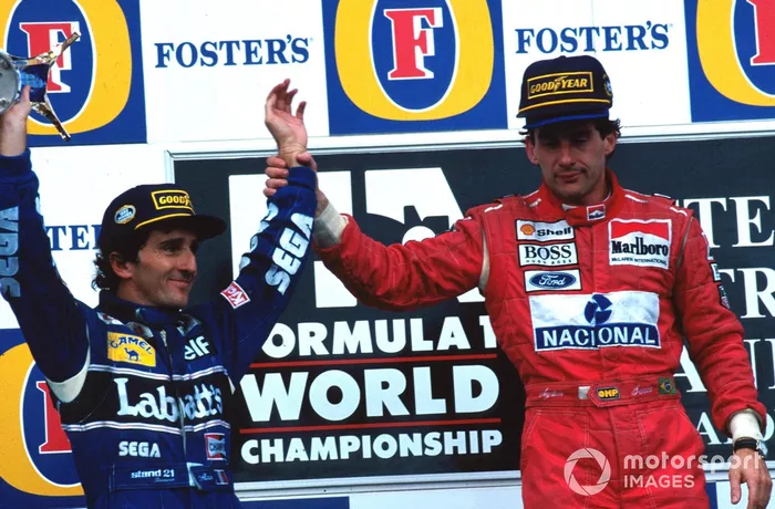 El ganador de la carrera, Ayrton Senna (McLaren), saluda al segundo clasificado y Campeón del Mundo, Alain Prost (Williams), en su última carrera antes de retirarse.