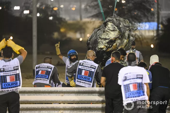 Los oficiales retiran los restos del monoplaza de Romain Grosjean, Haas VF-20, después del accidente en la primera vuelta