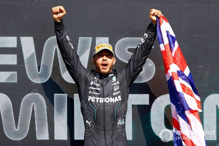 Lewis Hamilton, Mercedes-AMG F1 Team, 1ª posición, lo celebra en el podio con una bandera de la Unión.