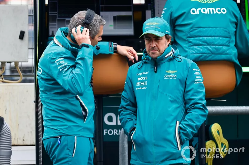 Fernando Alonso, Aston Martin F1 Team, s'entretient avec un coéquipier dans la voie des stands. 
