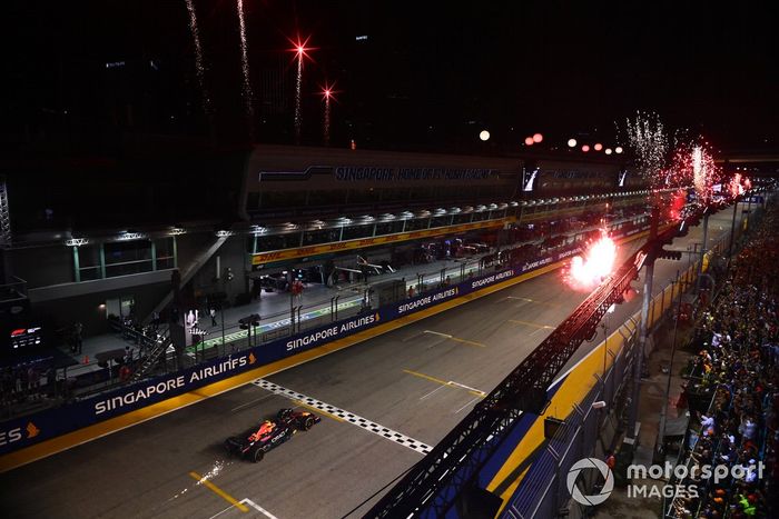Los fuegos artificiales iluminan el cielo mientras Sergio Pérez, el RB18 de Red Bull Racing, en primera posición, consigue la victoria