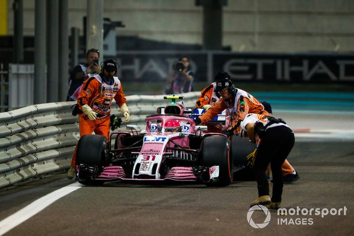 Oficiales mueven el auto de Esteban Ocon, Racing Point Force India VJM11, mientras se retira de la carrera por problemas técnicos
