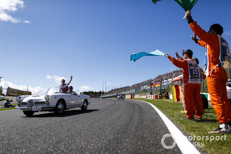 Des commissaires agitent des drapeaux alors que Charles Leclerc, Sauber, passe lors de la parade des pilotes