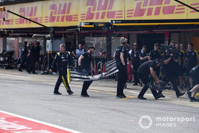 Los mecánicos recogen el alerón delantero roto de Nico Hulkenberg, Renault R.S. 19