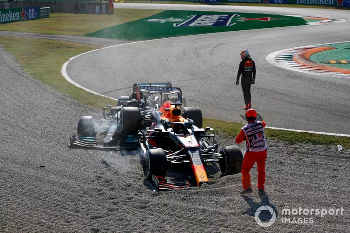 Max Verstappen, Red Bull Racing, se aleja mientras un oficial de pista asiste en el lugar de su accidente con Lewis Hamilton, Mercedes W12
