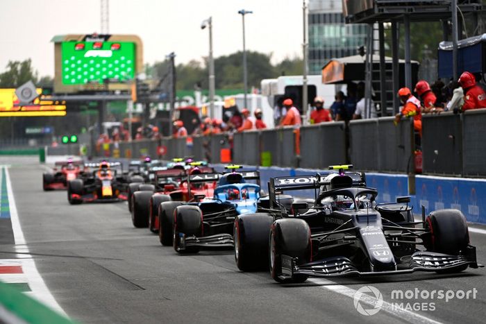Pierre Gasly, AlphaTauri AT02, Esteban Ocon, Alpine A521, and Carlos Sainz Jr., Ferrari SF21, en el pit lane