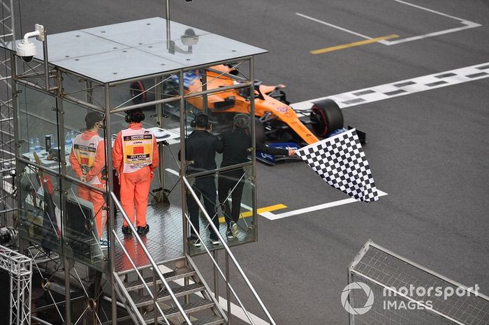 3 times world champion Alain Prost waves the chequered flag as Carlos Sainz Jr., McLaren MCL34 passes