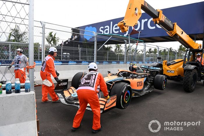 Los oficiales de pista retiran el coche dañado de Lando Norris, McLaren MCL36, del circuito