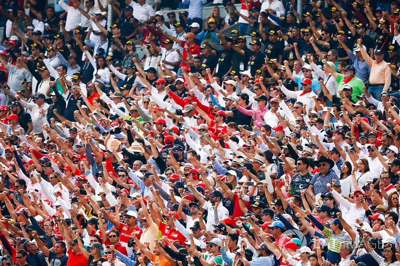 A huge crowd cheers for the drivers during the race