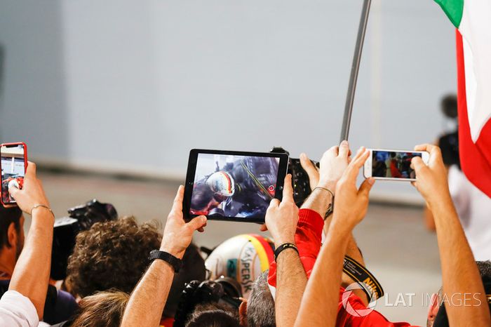 I membri del team fotografano l'arrivo di Sebastian Vettel, Ferrari, 1° classificato, nel parco chiuso