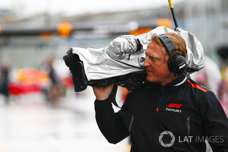 An F1 TV Cameraman with his equipment protected from the rain