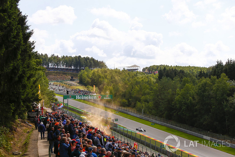 Charles Leclerc, Sauber C37, passes an orange flare and spectators
