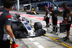 Kevin Magnussen, Haas F1 Team VF-17, stops in his pit garage as Nico Hulkenberg, Renault Sport F1 Te