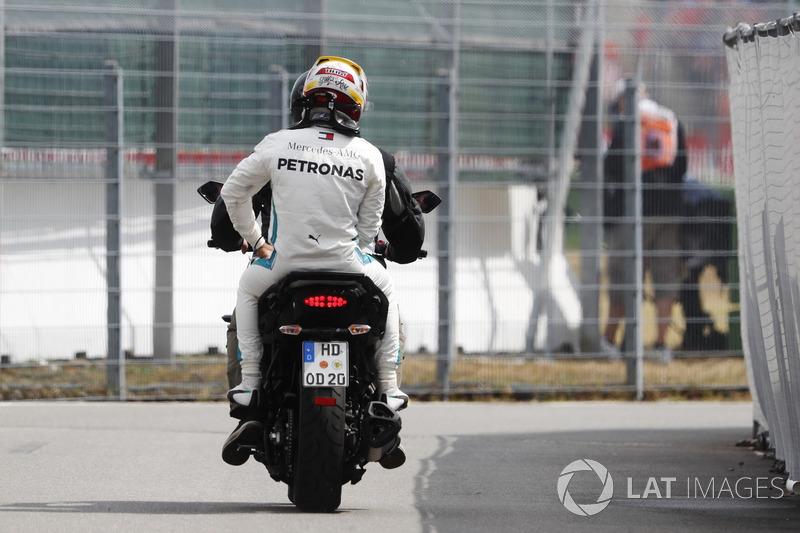 Lewis Hamilton, Mercedes AMG F1, regresa a boxes en la parte trasera de una motocicleta