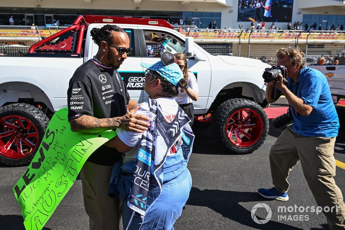 Lewis Hamilton, da Mercedes-AMG F1 Team, abraça um voluntário na pista antes da parada dos pilotos 
