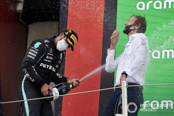 Lewis Hamilton, Mercedes, primera posición, derrama champán a su compañero de equipo en el podio