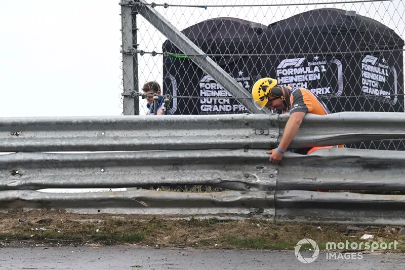 A marshal inspects a section of Armco barrier after a crash for Logan Sargeant, Williams FW46