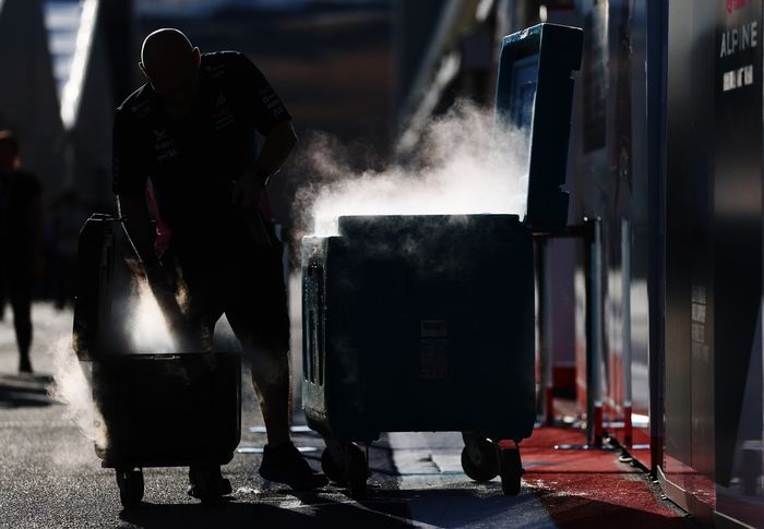 An Alpine F1 team member works with dry ice