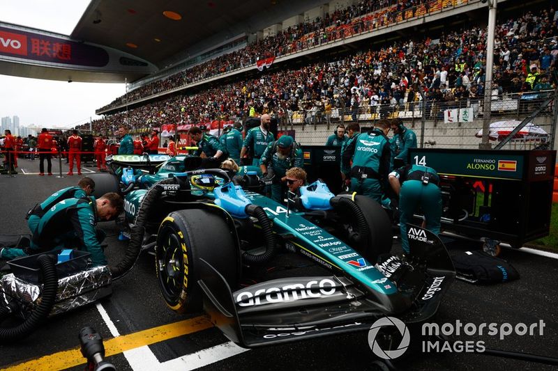 Meccanici al lavoro sulla vettura di Fernando Alonso, Aston Martin AMR24, sulla griglia di partenza