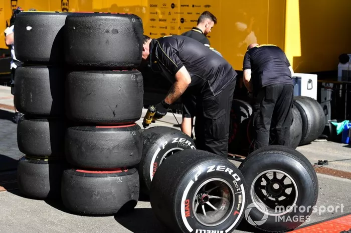 Técnicos de Pirelli con una pila de neumáticos