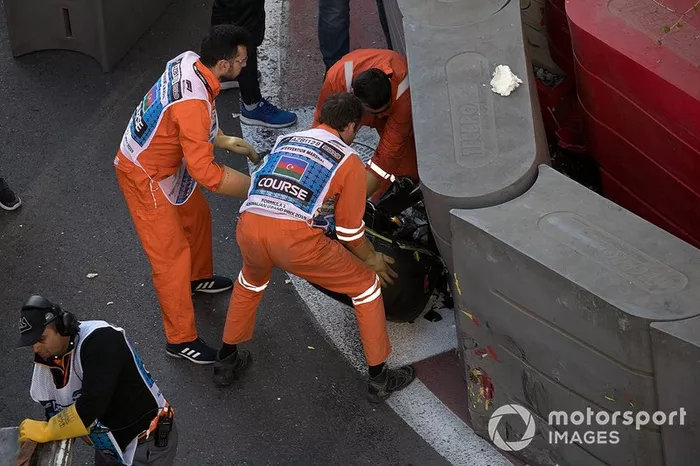 Los oficiales retiran el coche accidentado de Charles Leclerc, Ferrari SF90