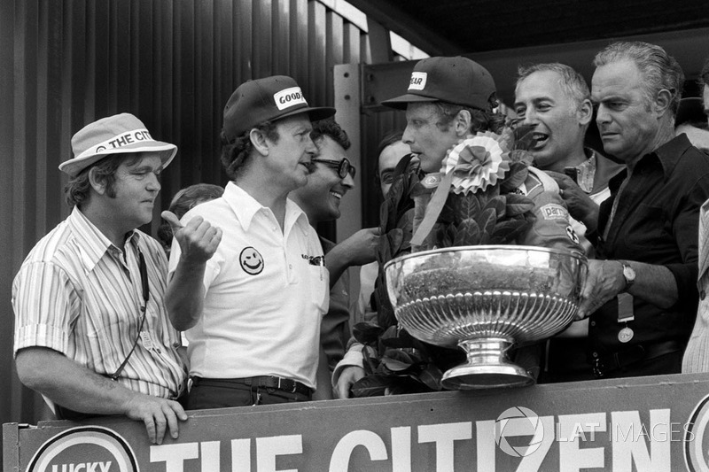 Podium: Bert Baldwin, Goodyear informs race winner Niki Lauda, Ferrari of the tragic fatal accident 