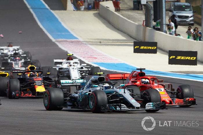 Valtteri Bottas, Mercedes AMG F1 W09, con Sebastian Vettel, Ferrari SF71H, en la salida