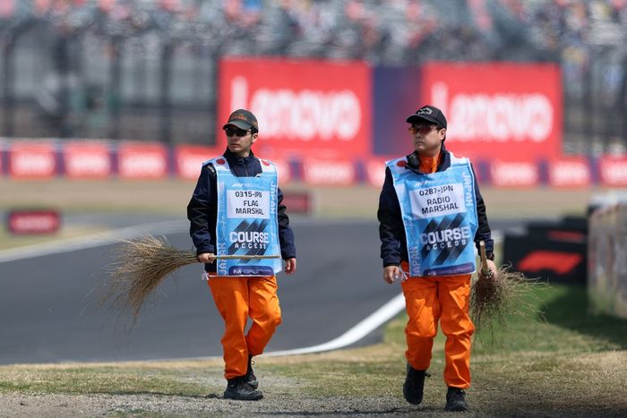 Marshals sweep the track.