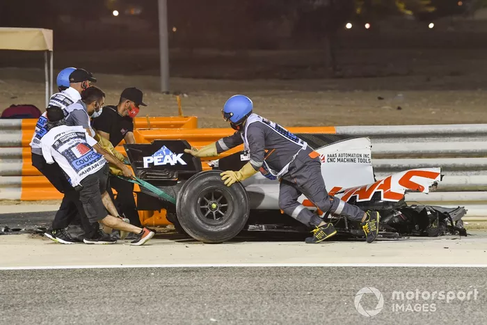 Los oficiales retiran los restos del monoplaza de Romain Grosjean, Haas VF-20, después del accidente en la primera vuelta
