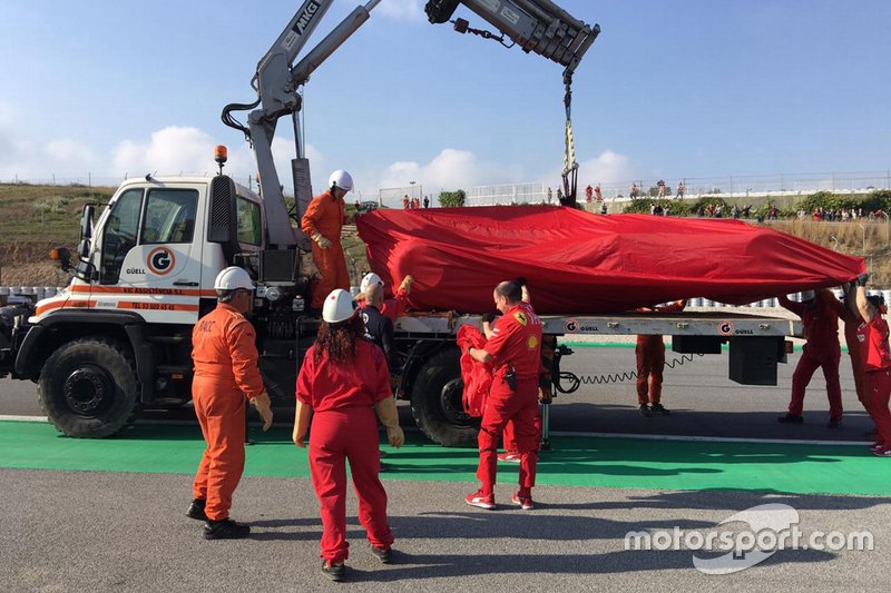 The Ferrari SF90 of Sebastian Vettel is recovered on a truck
