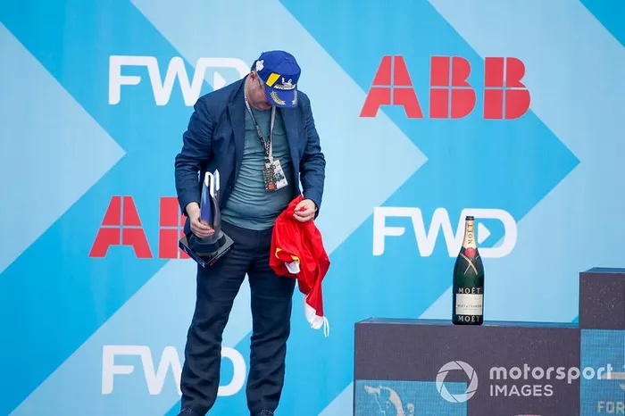 A DS TECHEETAH representative on the podium with the winner's trophy