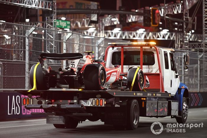 El coche de Carlos Sainz, Ferrari SF-23, regresa a boxes tras los daños causados por una tapa de alcantarilla