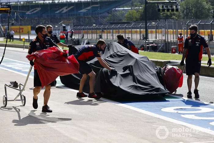 Los mecánicos de Red Bull con el monoplaza dañado de Alex Albon, Red Bull Racing RB16 en el garaje bajo una lona después de su accidente en la FP2