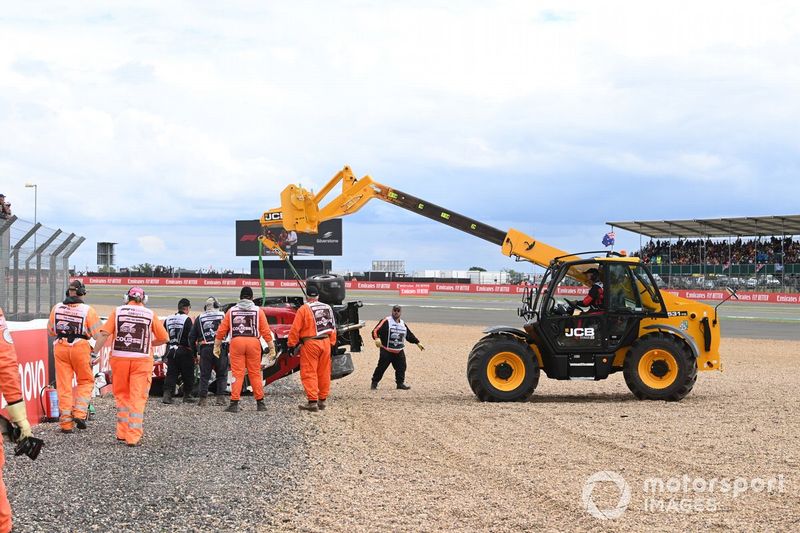 Los oficiales de pista retiran el coche dañado de Zhou Guanyu, Alfa Romeo C42