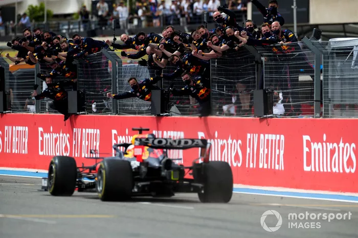Max Verstappen, Red Bull Racing RB16B, 1ª posición, cruza la línea de meta para la victoria entre los vítores de su equipo en el muro de boxes